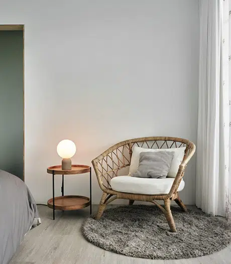 Coin lecture avec fauteuil en rotin et lampe de chevet